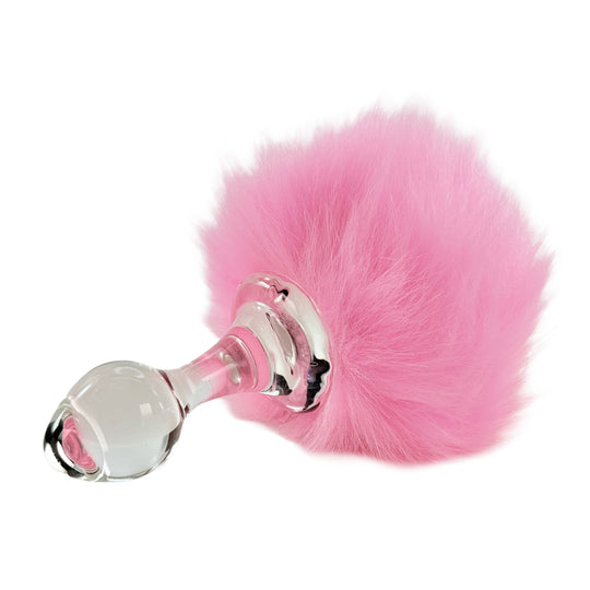 A pink faux fur bunny tail attached to a clear glass butt plug, showcasing the product's design and the fluffy texture of the tail.